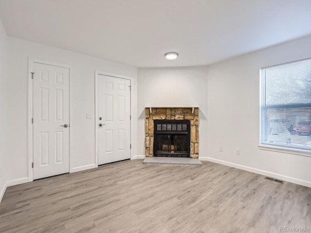 unfurnished living room with a fireplace and light hardwood / wood-style floors