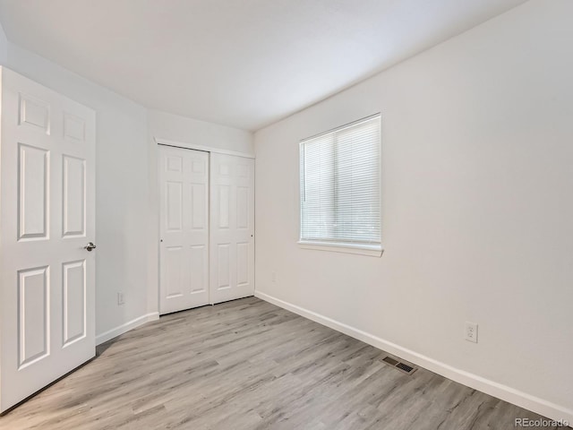 unfurnished bedroom featuring light hardwood / wood-style floors and a closet