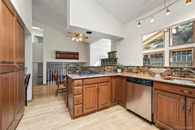 kitchen featuring a sink, brown cabinetry, light wood-style floors, and stainless steel appliances