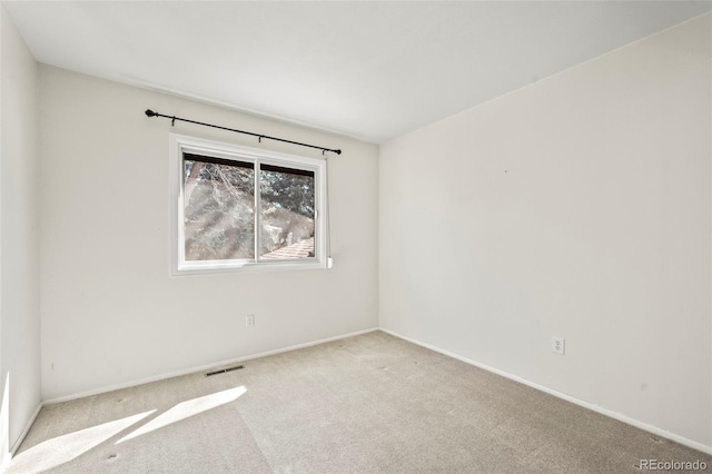 carpeted empty room featuring visible vents and baseboards