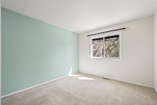 carpeted empty room with visible vents and baseboards