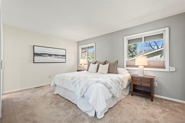 bedroom featuring light colored carpet and baseboards