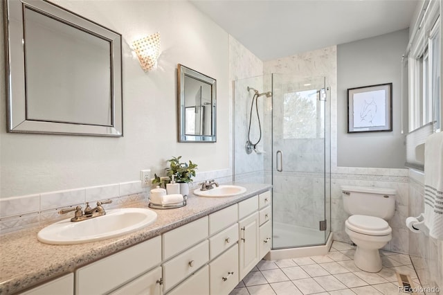 full bath with a sink, toilet, tile walls, and a stall shower