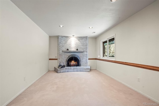 unfurnished living room featuring carpet, visible vents, baseboards, recessed lighting, and a fireplace