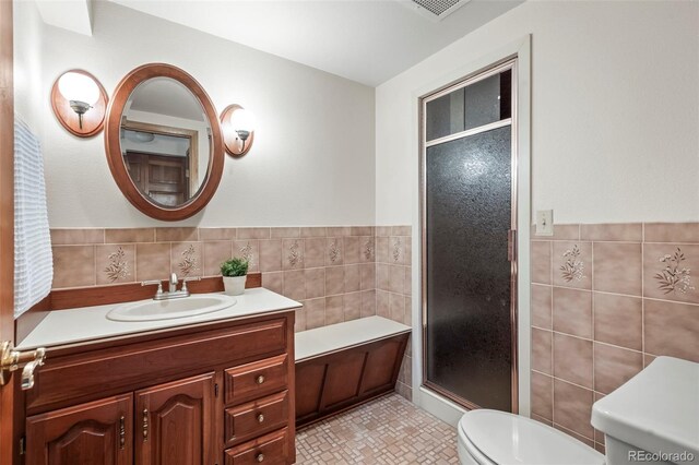 full bath with vanity, tile walls, toilet, and a stall shower