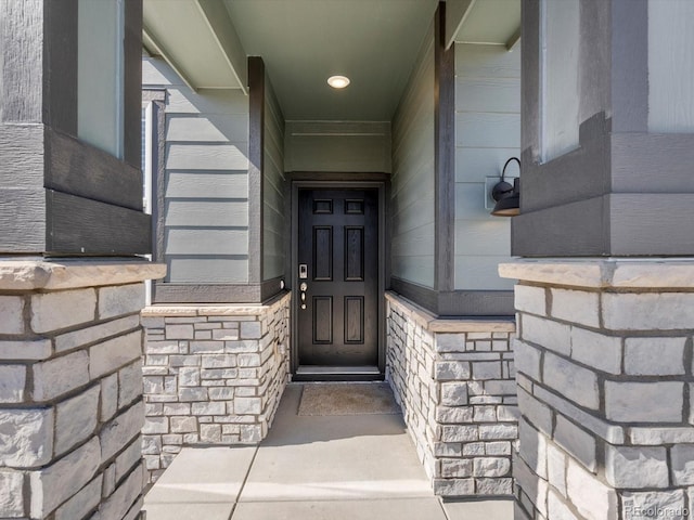 doorway to property featuring stone siding