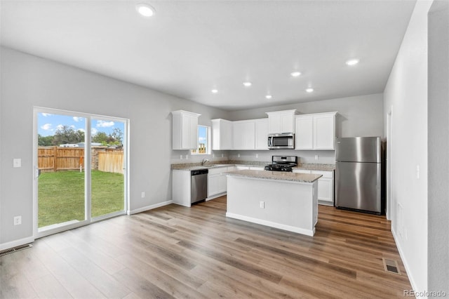 973 Cascade Falls St, Severance, CO 80550 - kitchen featuring appliances with stainless steel finishes, a sink, recessed lighting, wood finished floors, and white cabinets
