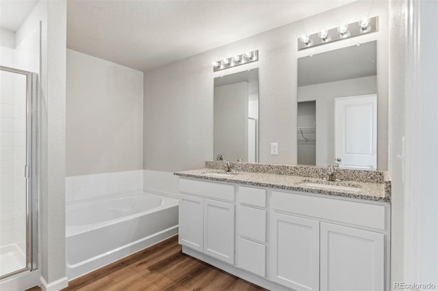 973 Cascade Falls St, Severance, CO 80550 - full bathroom featuring a shower stall, a bath, double vanity, and wood finished floors