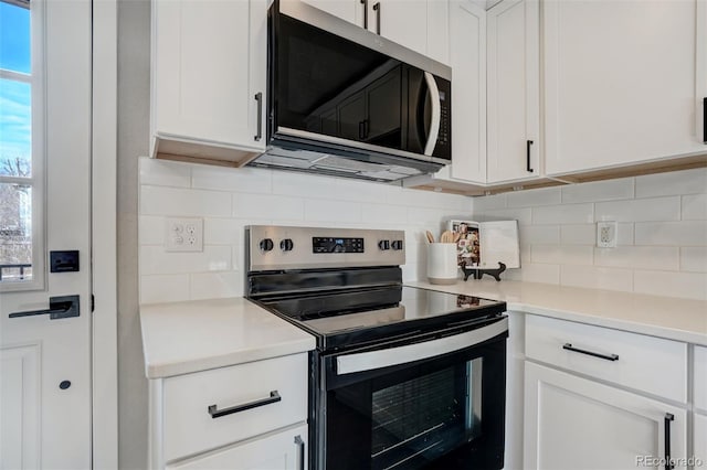 kitchen with backsplash, white cabinets, and appliances with stainless steel finishes