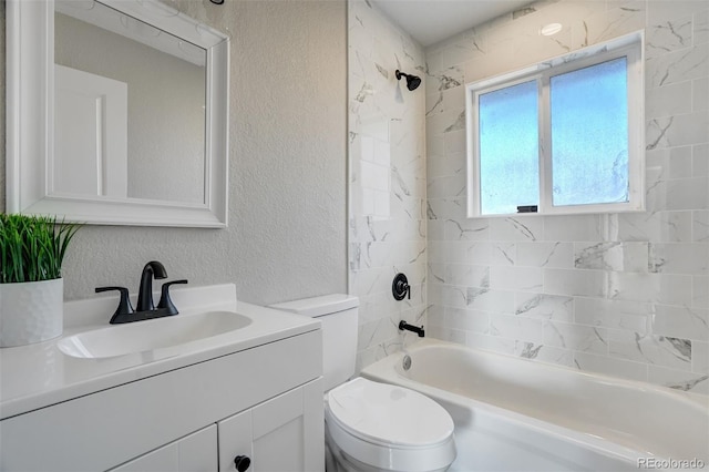 full bathroom featuring vanity, toilet, and tiled shower / bath