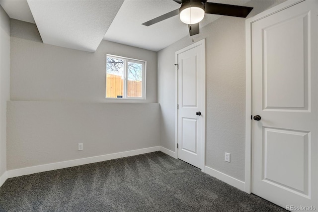 unfurnished bedroom featuring dark colored carpet and ceiling fan