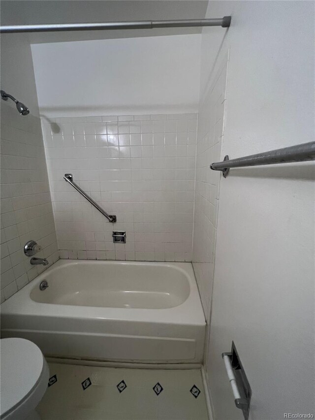 bathroom with tile patterned floors, bathing tub / shower combination, and toilet