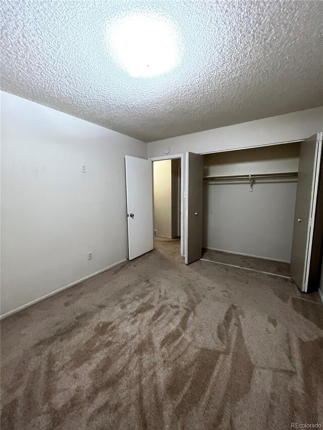 unfurnished bedroom featuring a closet, carpet floors, and a textured ceiling