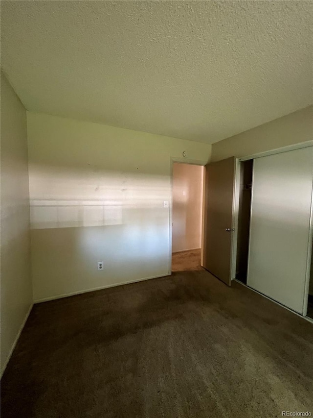 carpeted empty room featuring a textured ceiling