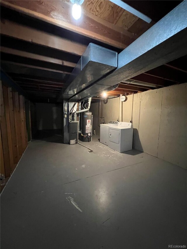 basement featuring separate washer and dryer, water heater, and heating unit