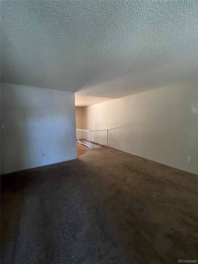 carpeted empty room featuring a textured ceiling