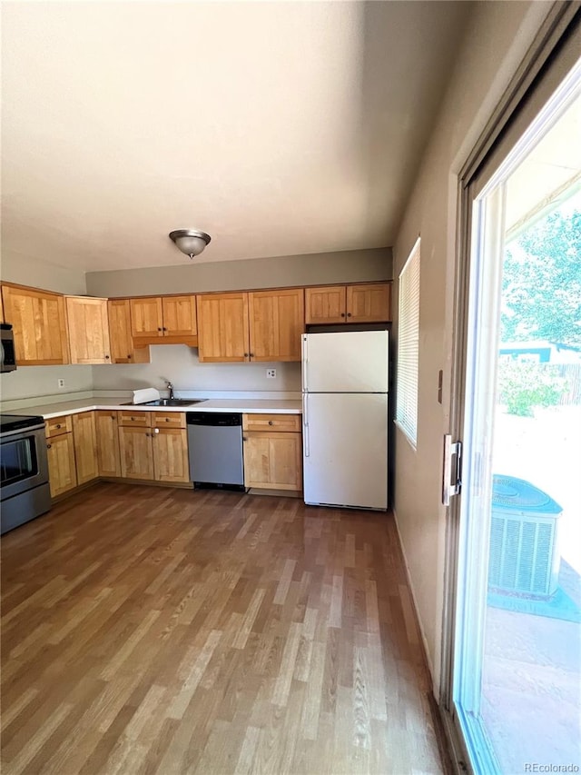 kitchen featuring stainless steel appliances, dark wood-type flooring, and sink