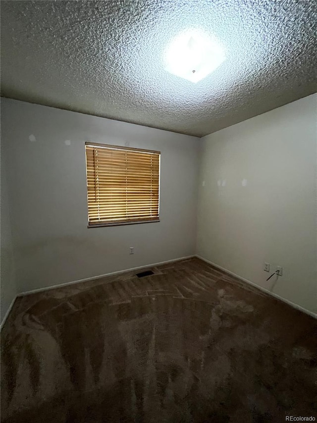 carpeted spare room featuring a textured ceiling