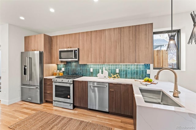1713 Grove St, Denver, CO 80204 - kitchen featuring stainless steel appliances, a sink, modern cabinets, tasteful backsplash, and light wood-style floors