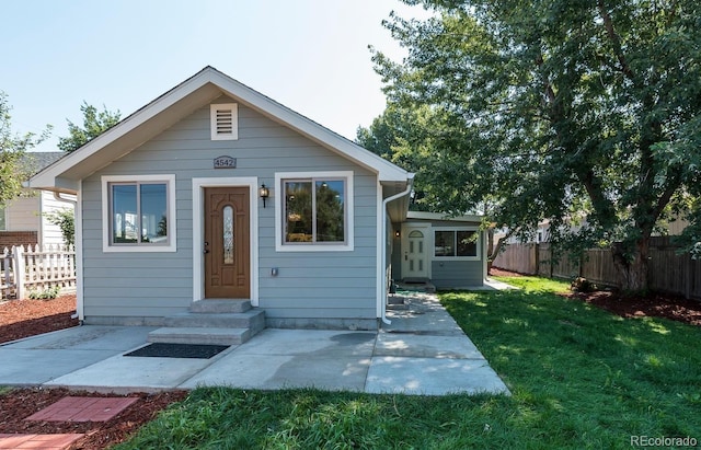 bungalow-style house featuring a patio and a front lawn