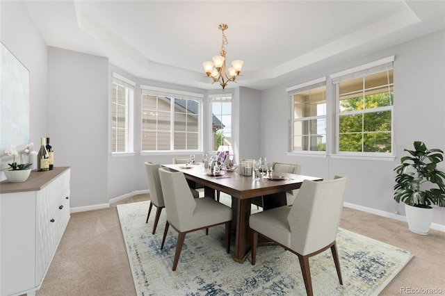 carpeted dining room with a raised ceiling and a notable chandelier