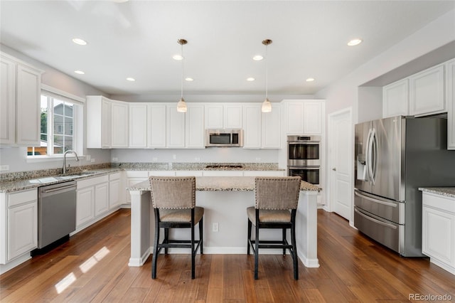 kitchen featuring white cabinetry, pendant lighting, a center island, and stainless steel appliances