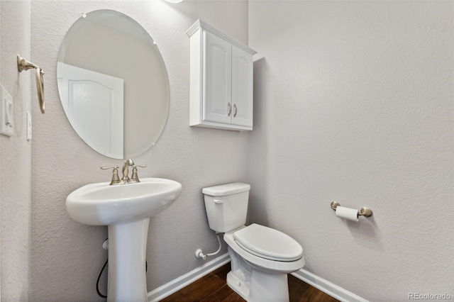 bathroom featuring sink, toilet, and hardwood / wood-style flooring