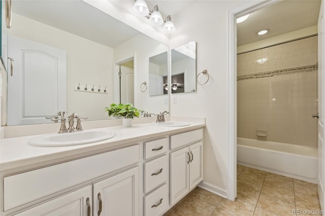 bathroom featuring tile patterned flooring, vanity, and tiled shower / bath