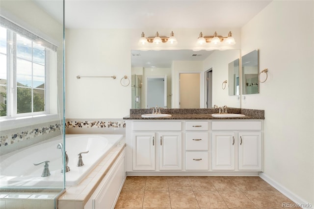 bathroom with vanity, tile patterned floors, and tiled tub