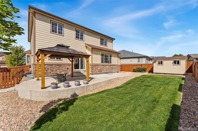 rear view of property with a gazebo, a patio area, a storage shed, and a lawn