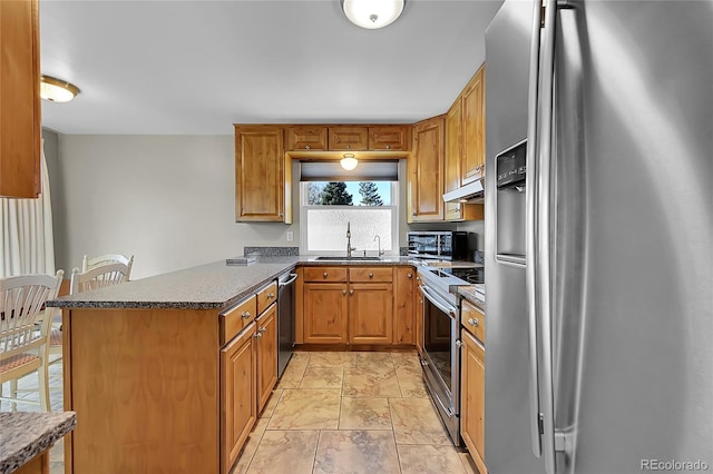 8160 W 81st Pl, Arvada, CO 80005 - kitchen with stainless steel appliances, a peninsula, dark countertops, and brown cabinets