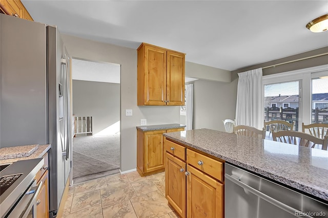 8160 W 81st Pl, Arvada, CO 80005 - kitchen with stainless steel appliances, stone counters, and brown cabinets