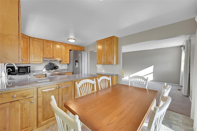 8160 W 81st Pl, Arvada, CO 80005 - kitchen with appliances with stainless steel finishes, light stone counters, under cabinet range hood, and a peninsula