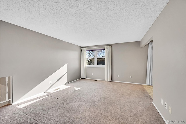 unfurnished room featuring light colored carpet and a textured ceiling