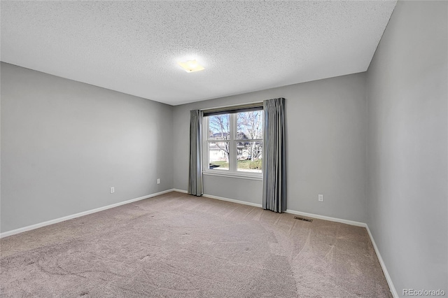 carpeted spare room with a textured ceiling