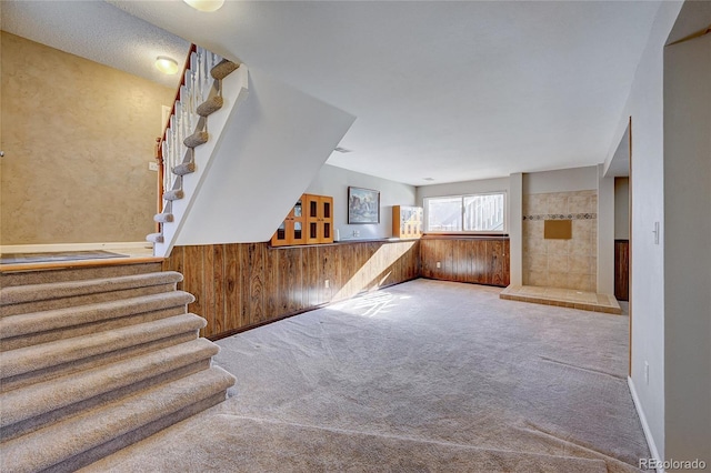 interior space with carpet and wood walls