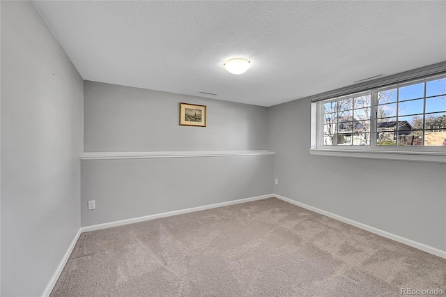 carpeted spare room with a textured ceiling