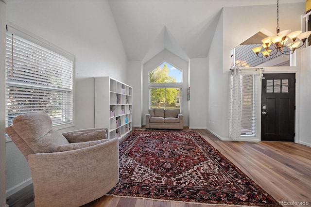 interior space featuring a notable chandelier, hardwood / wood-style floors, and high vaulted ceiling