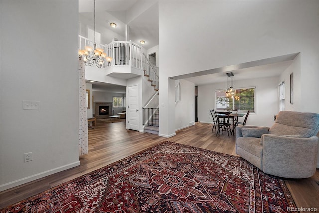 foyer featuring a towering ceiling, a notable chandelier, and wood-type flooring