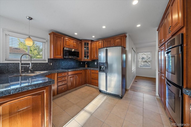 kitchen with hanging light fixtures, light tile patterned floors, tasteful backsplash, appliances with stainless steel finishes, and sink