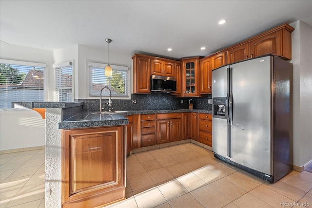 kitchen featuring appliances with stainless steel finishes, hanging light fixtures, a healthy amount of sunlight, and sink