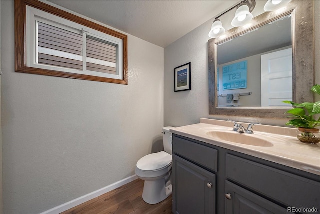 bathroom featuring toilet, vanity, a textured ceiling, and hardwood / wood-style floors