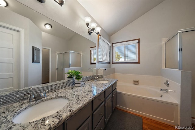 bathroom with vaulted ceiling, separate shower and tub, wood-type flooring, and vanity