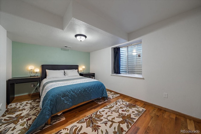 bedroom featuring a textured ceiling and hardwood / wood-style floors