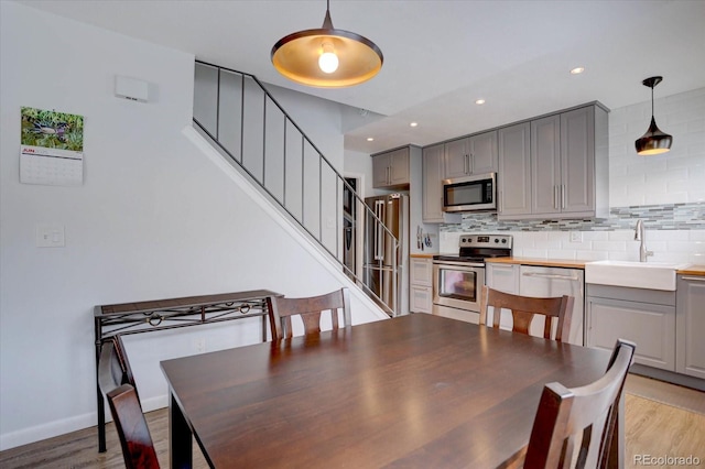 1769 S Lee St Unit B, Lakewood, CO 80232 - dining space with stairway, light wood finished floors, baseboards, and recessed lighting