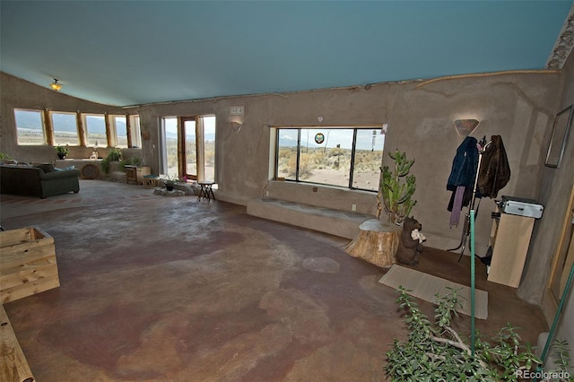 misc room with concrete flooring and vaulted ceiling