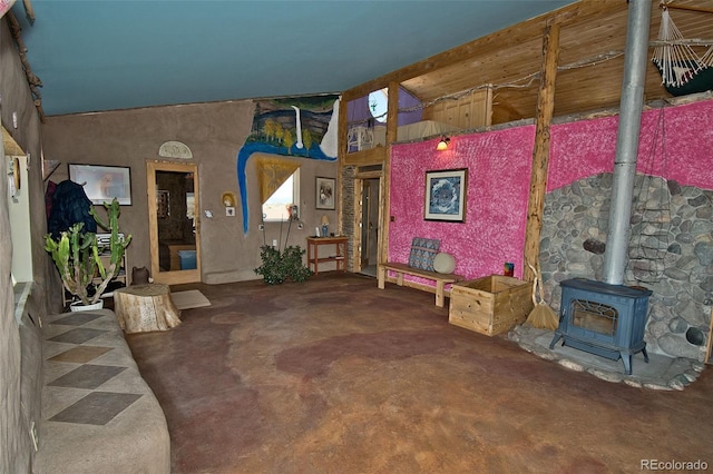 interior space featuring carpet flooring, a wood stove, and high vaulted ceiling