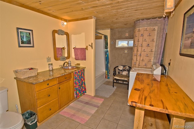 bathroom with washing machine and dryer, tile patterned flooring, wood ceiling, and toilet