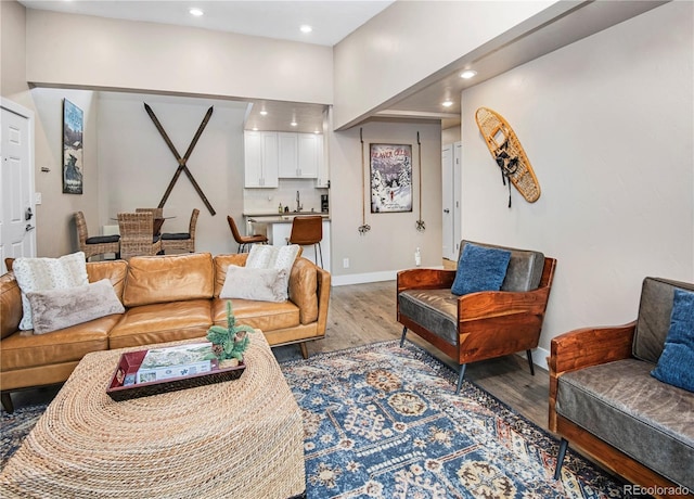 living area featuring baseboards, wood finished floors, and recessed lighting