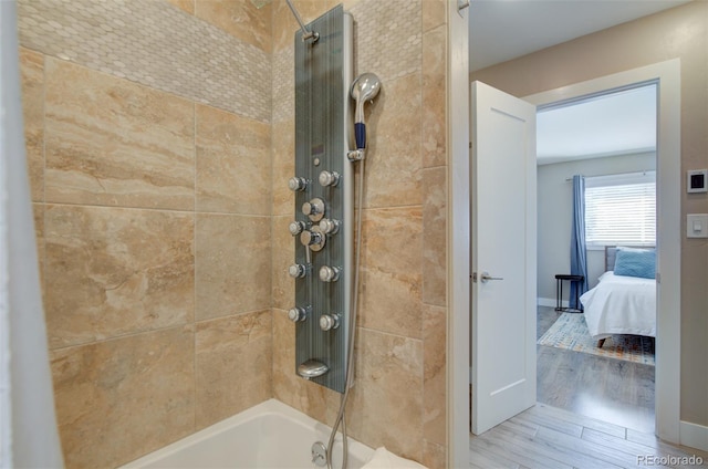 interior details featuring shower / washtub combination, connected bathroom, and wood finished floors